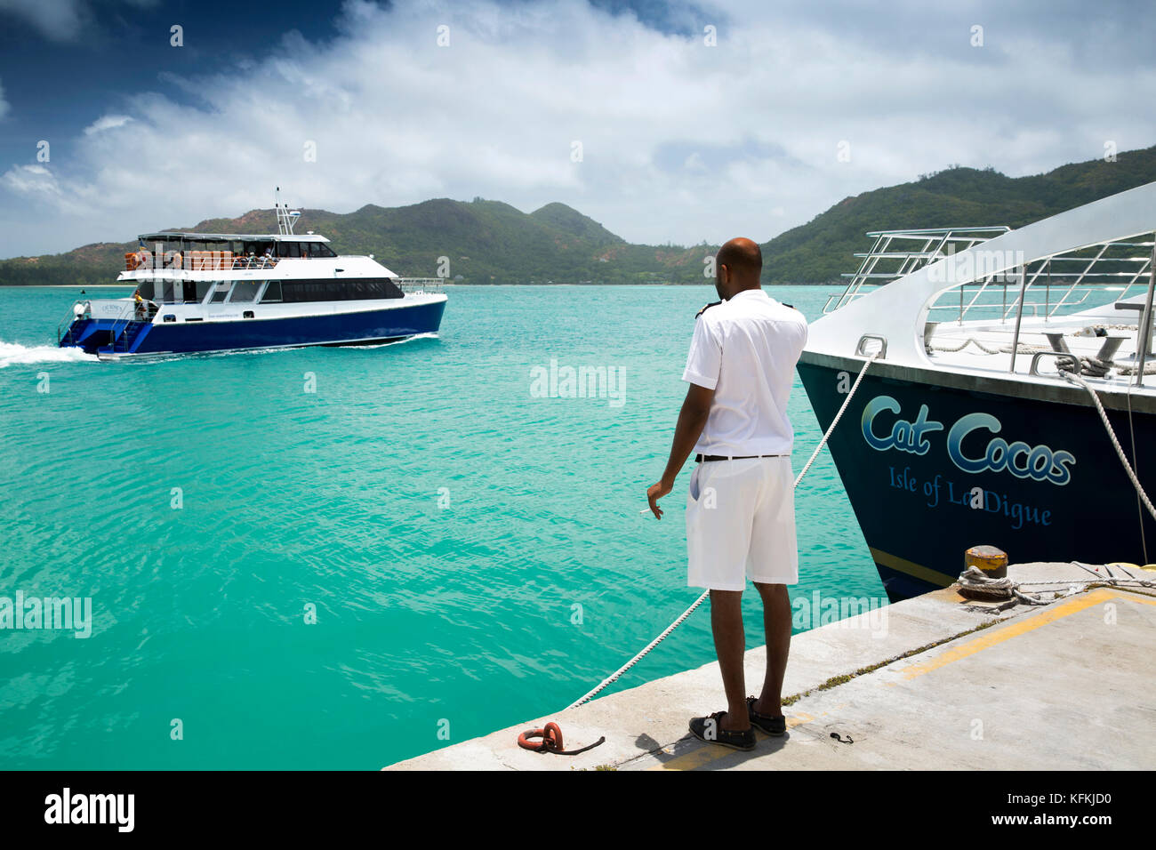 The Seychelles, Praslin, Baie St Anne, jetty, Port Victoria, deck officer watching Cat Rose ferry boat Stock Photo