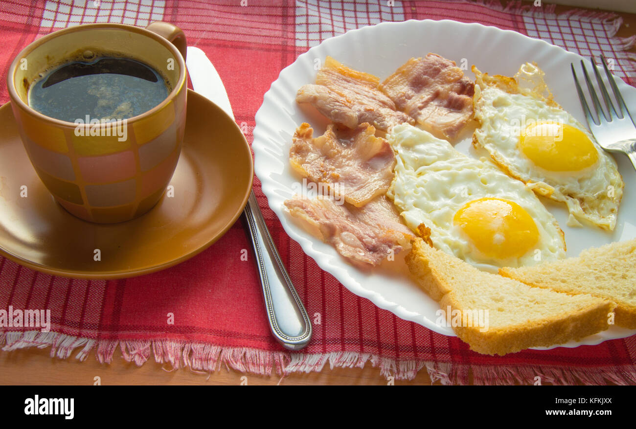 Delicious Breakfast - a Cup of coffee, a plate of fried eggs, bacon and ...