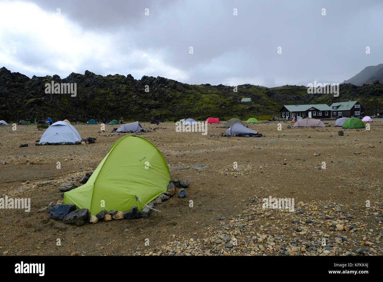 Campers in field and tents held down by rocks to avoid strong winds at ...