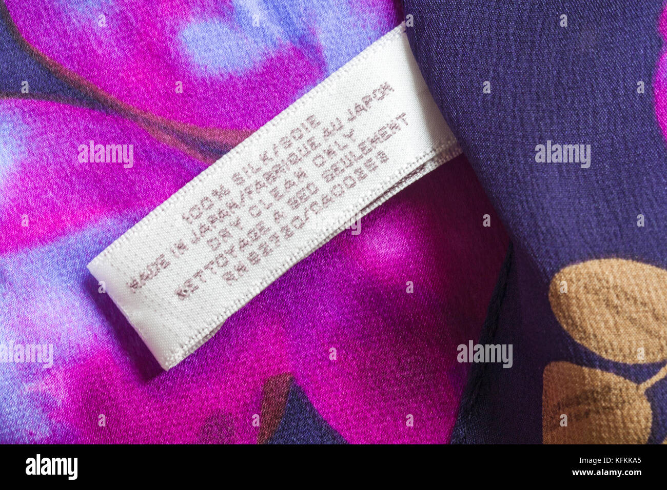 Label in woman's 100% silk scarf made in Japan, pink, blue, purple colours - dry clean only - sold in the UK United Kingdom, Great Britain Stock Photo