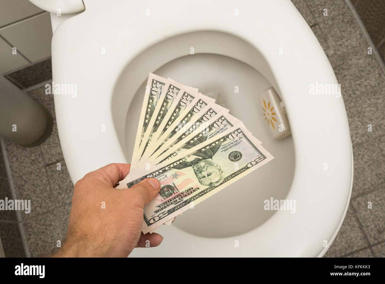 Hand throwing 100 dollar bills in toilet Stock Photo Alamy