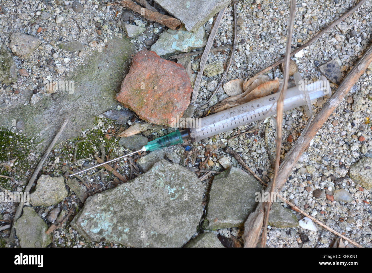 Discarded syringe and on ground used by heroin addict. Stock Photo