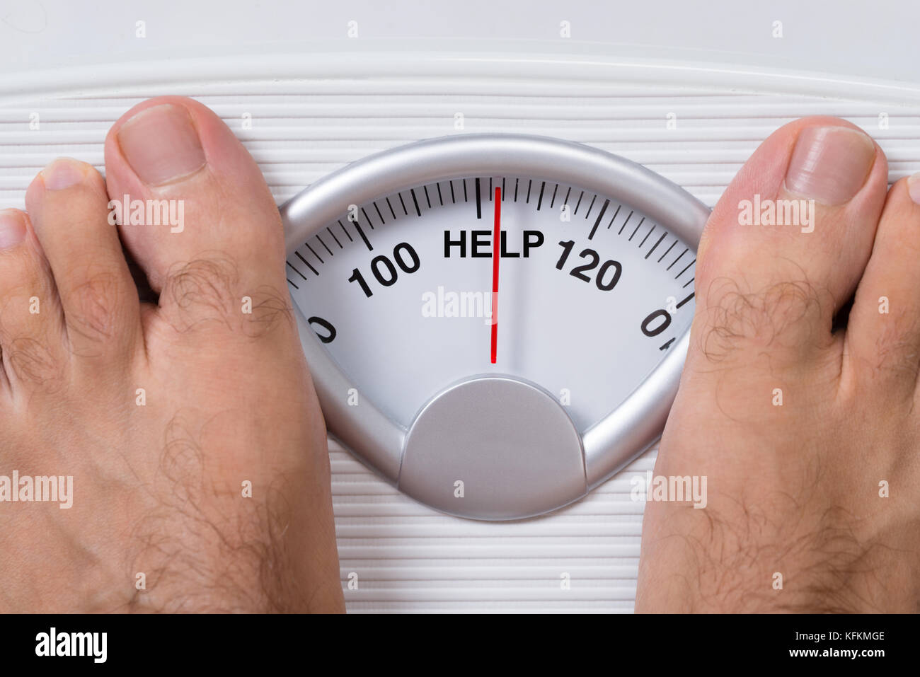 Closeup of man's feet on weight scale indicating Help Stock Photo