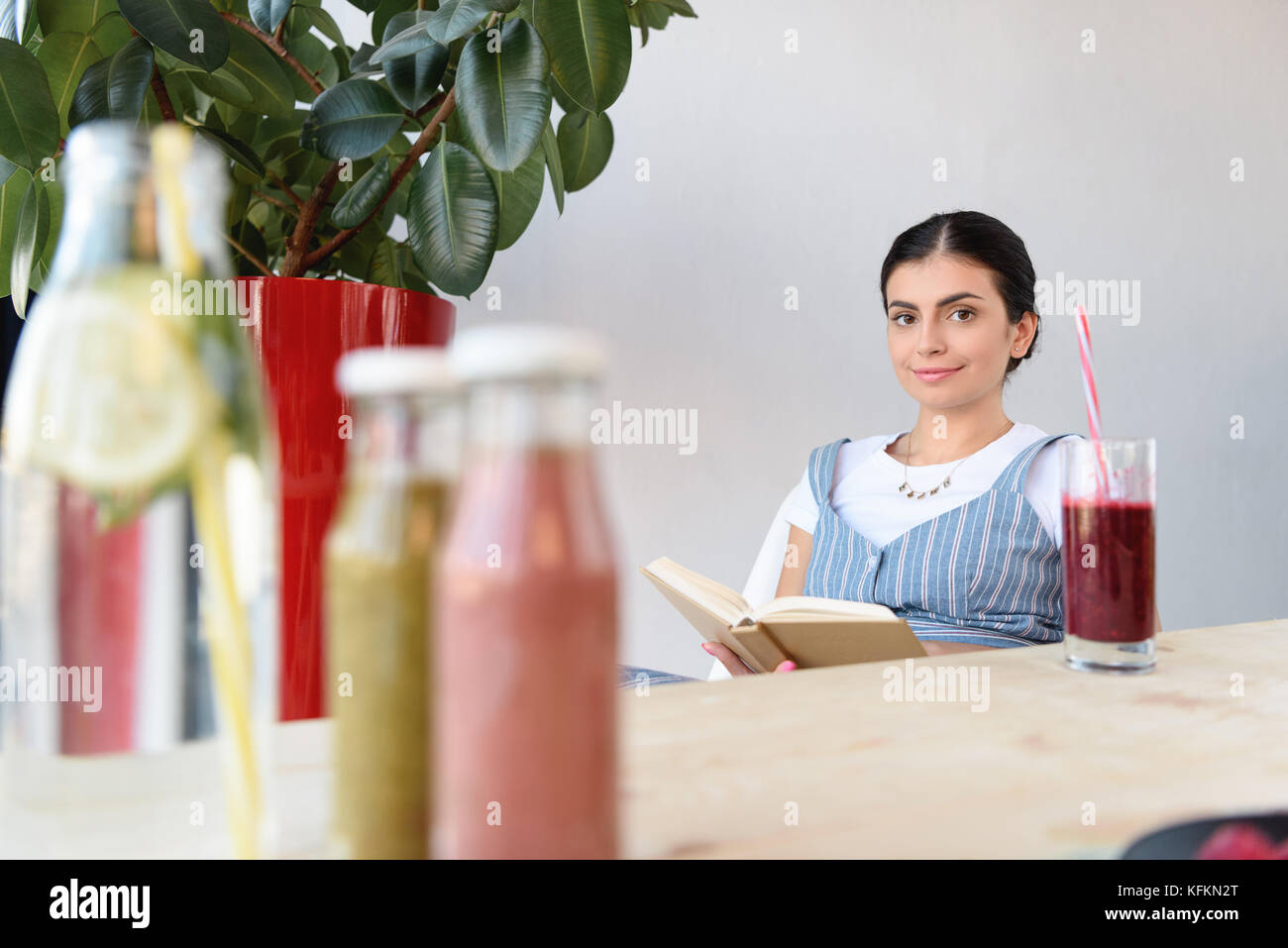 woman reading book at table Stock Photo - Alamy