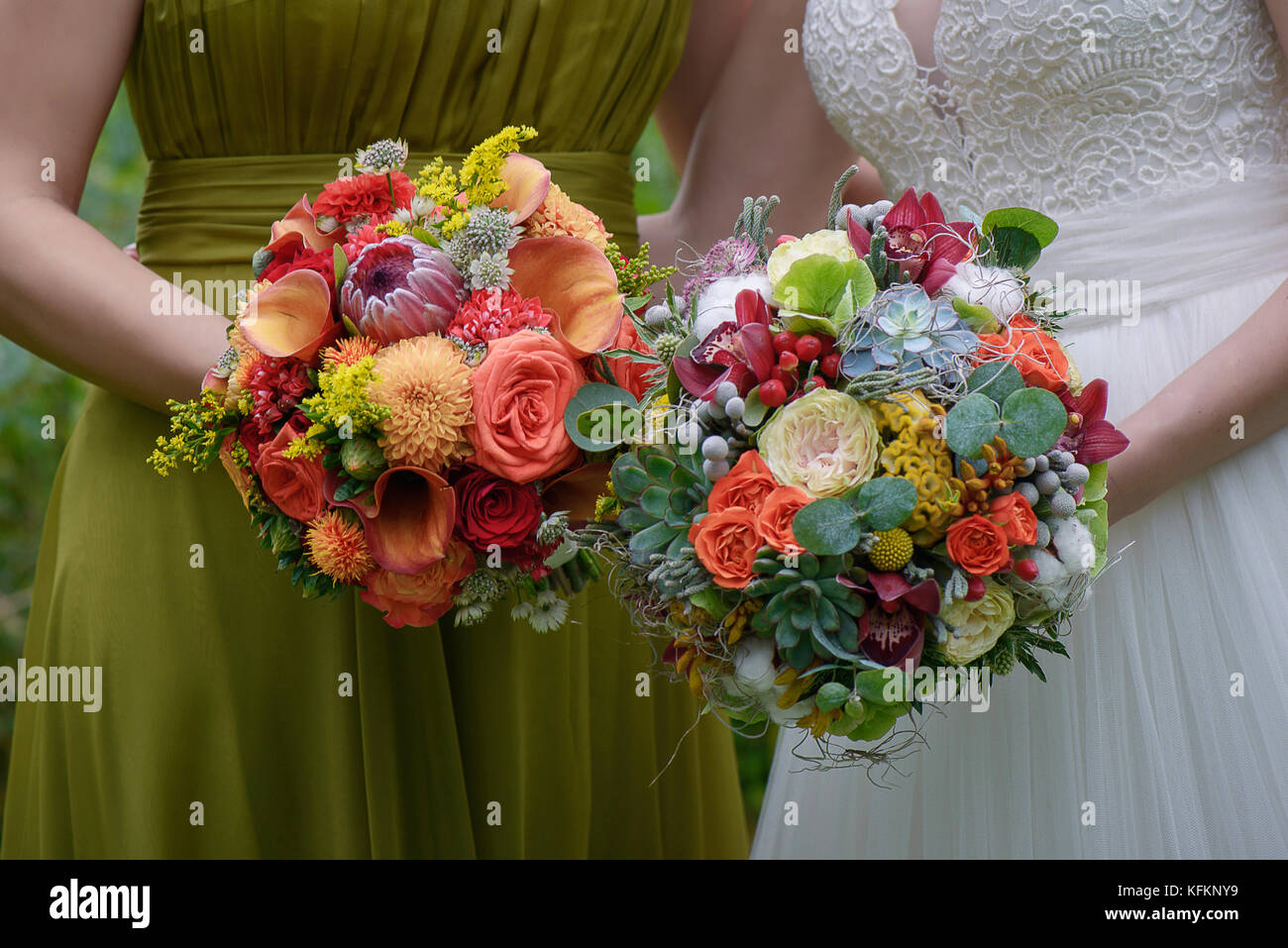 Close-up shot of bride and bridesmaid holding large colorful and sophisticated wedding bouquets Stock Photo
