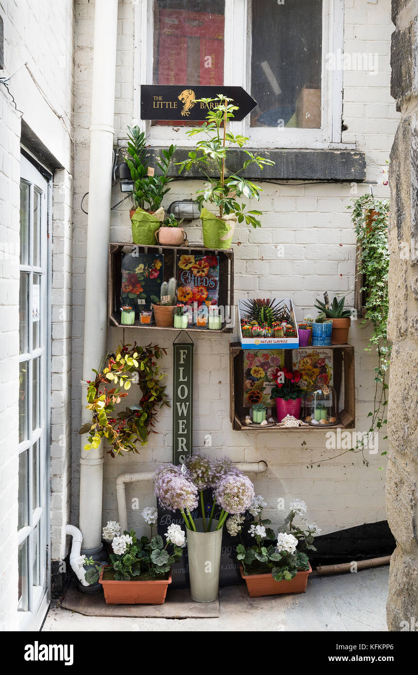 Flower shop overspill in narrow passage serving small shops in Braddford on Avon Wiltgshire England UK Stock Photo