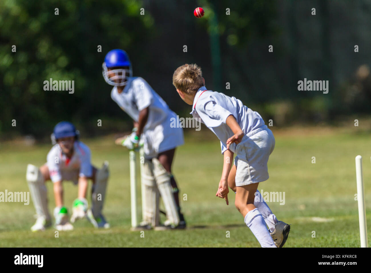 Cricket game juniors players bowler Batsman wicket keeper unidentified action abstract. Stock Photo