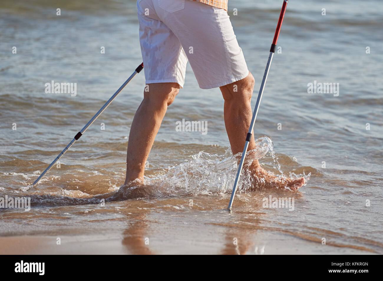 Detail of an old woman walking in the sea for exercise Stock Photo