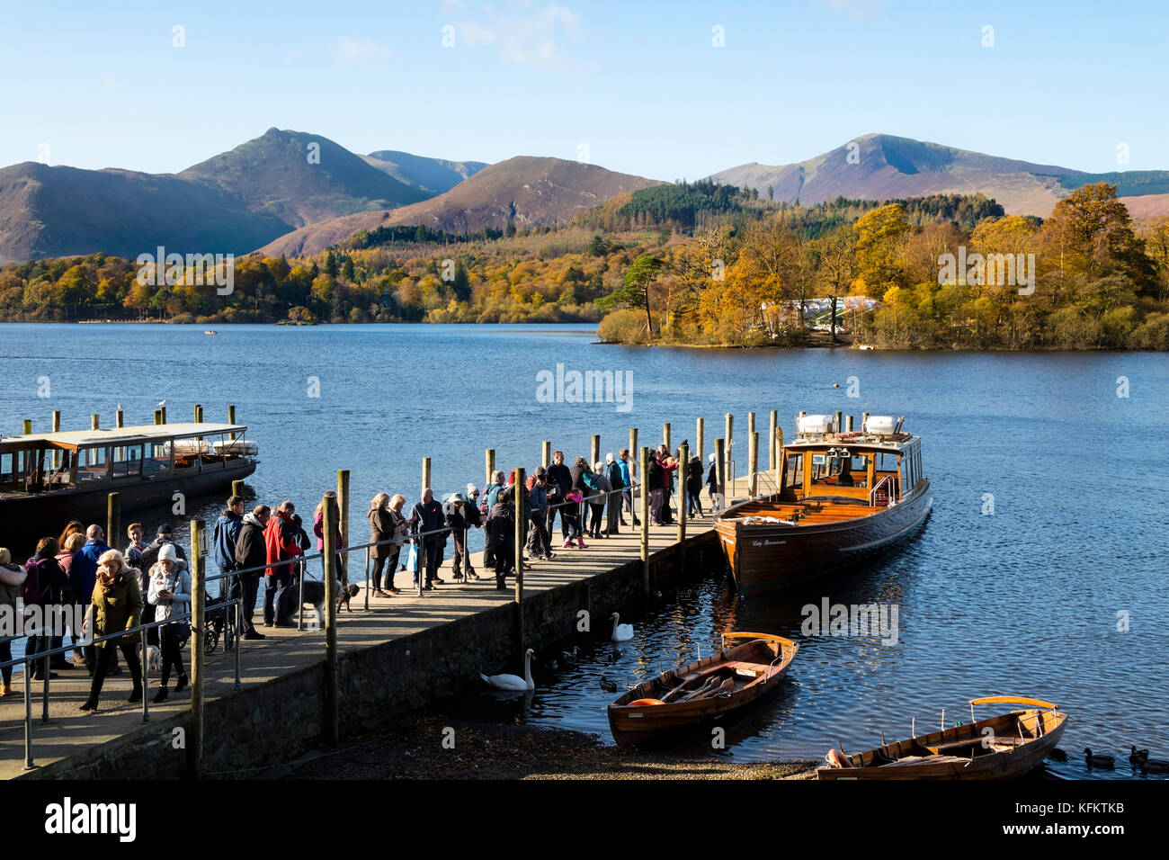 Keswick, Lake District, Cumbria. Sunday 29th October 2017. UK Weather. On a beautiful autumnal morning people queue in the sunshine for a boat rides on Derwent Water. Credit: David Forster/Alamy Live News Stock Photo