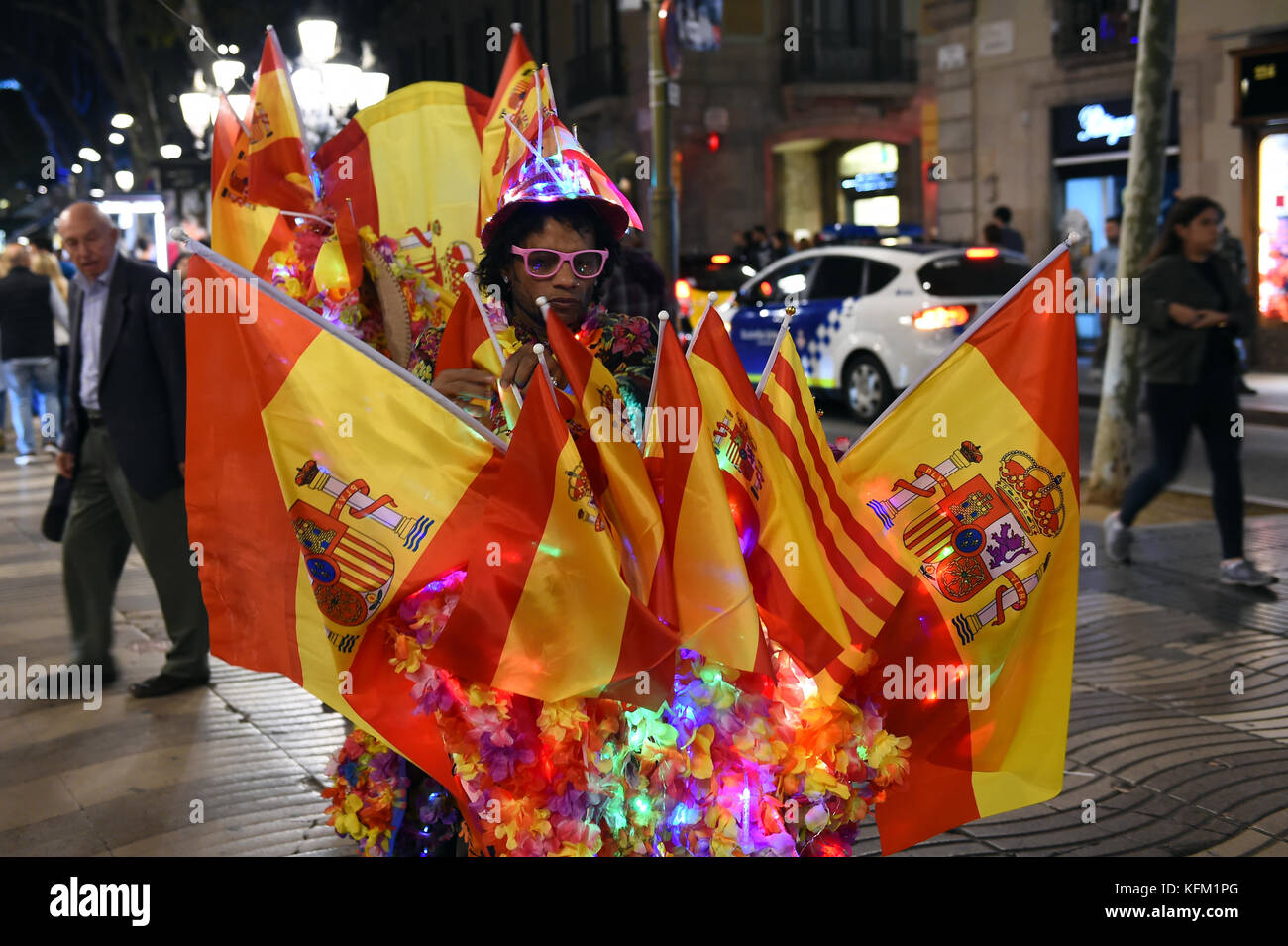 The light artist Jamal drives on his colourfully decorated bicycle with Spanish flags across Barcelona, 29 Octoebr 2017. Jamal, who is of Jamaican origin, attached several paper flowers, chain of lights and Spanish flags to his bike and drives around the streets in the night time. 'This is my personal demonstration for the unity of Spain', says Jamal. Photo: Andrej Sokolow/dpa Stock Photo