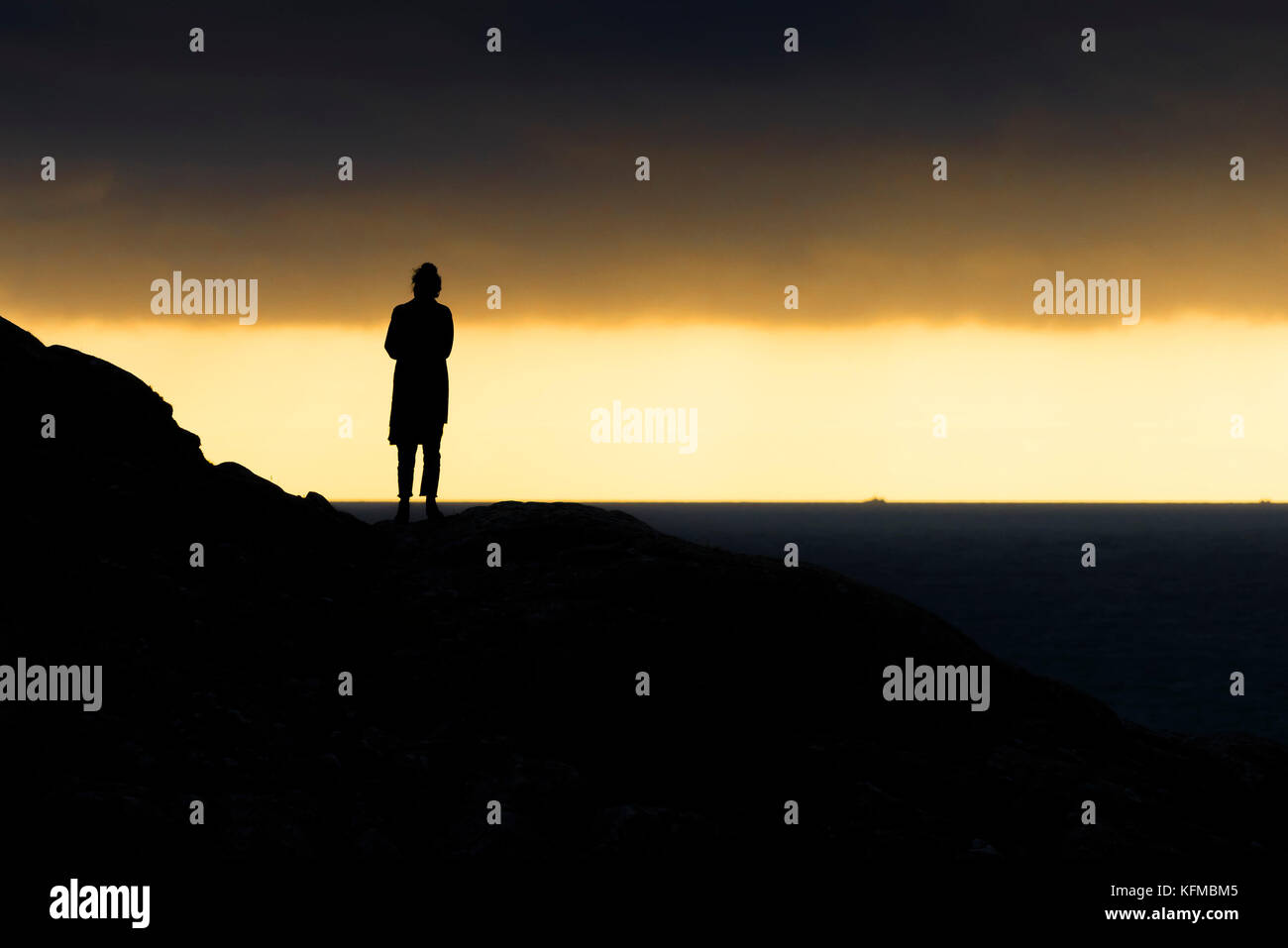 Silhouettes - a solitary woman silhouetted against evening light. Stock Photo