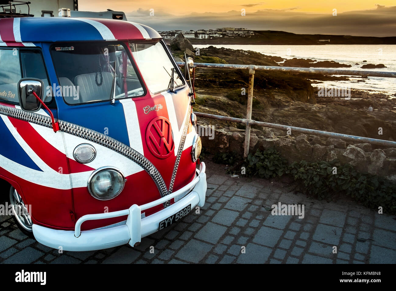 A vintage Volkswagen Camper van painted in the colours of the Union Flag parked at little Fistral in Newquay Cornwall. Stock Photo