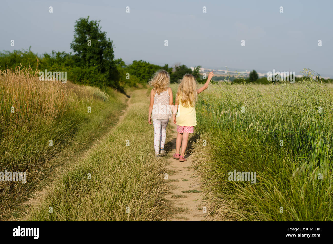 two girls walking together in the country Stock Photo - Alamy