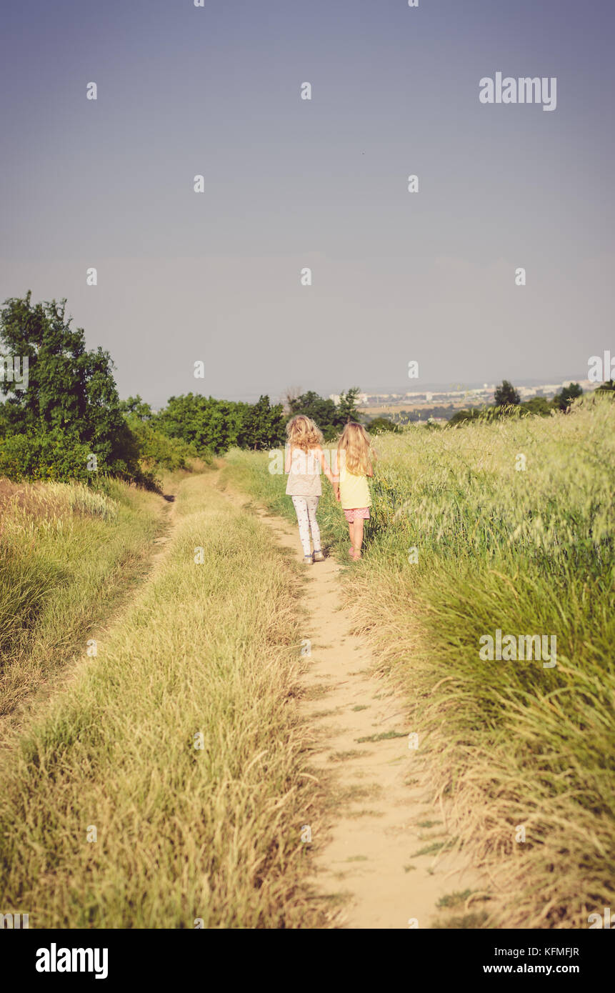 two girls walking together in the country Stock Photo - Alamy