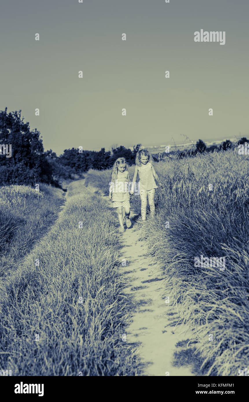 two girls walking together in the country Stock Photo - Alamy