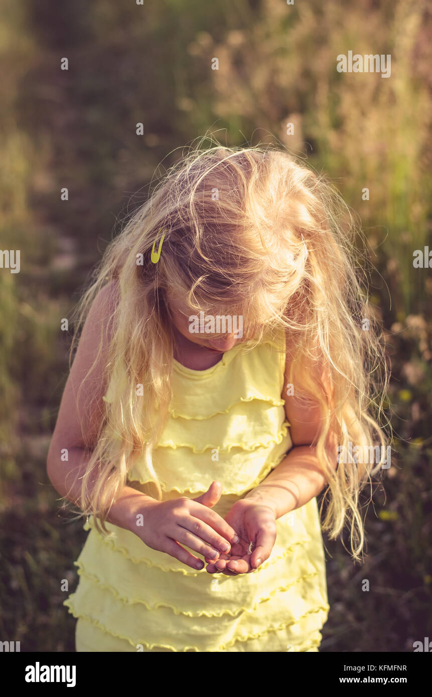 little blond girl walking in rural path among fields Stock Photo - Alamy