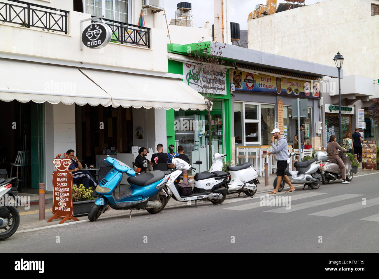 Malia, Crete, Greece. Scooters parked outside shops along the main street. October 2017 Stock Photo
