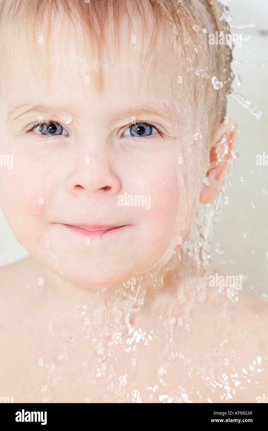 Portrait of cute little girl with water dripping through her head Stock