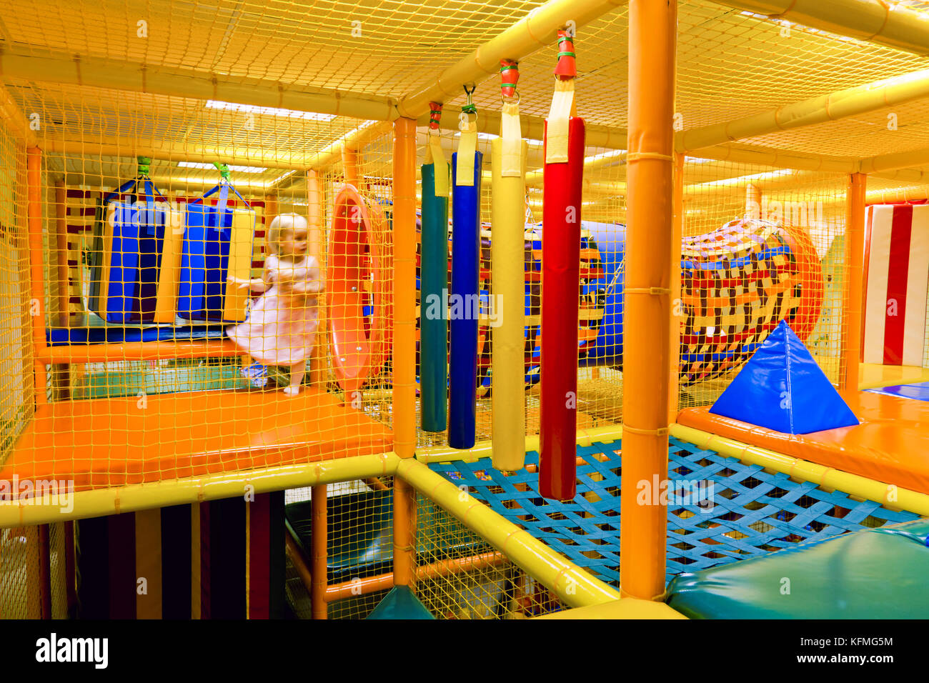 Little girl playing inside of maze playground Stock Photo