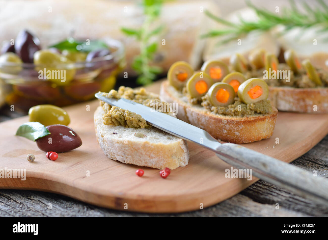 Olive paste on baked olive baguette, decorated with stuffed green