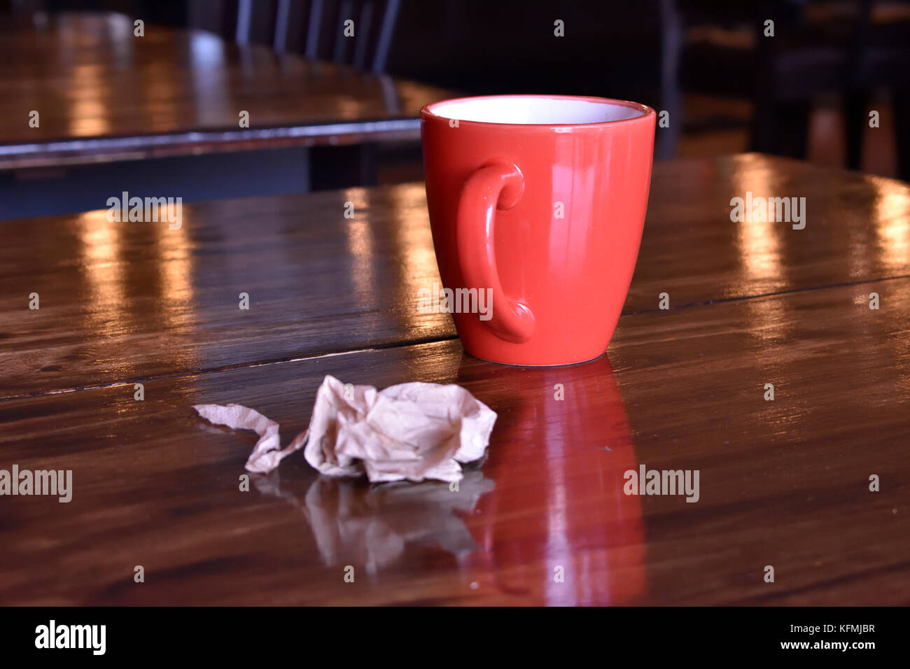 Coffee mug and used napkin on empty table in coffee shop in Sidney, BC