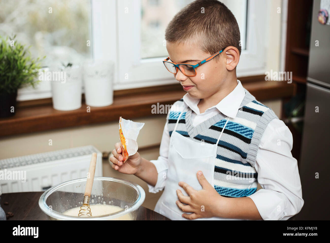 7-year-old-boy-mixing-ingredients-for-baking-a-cake-adding-in-baking