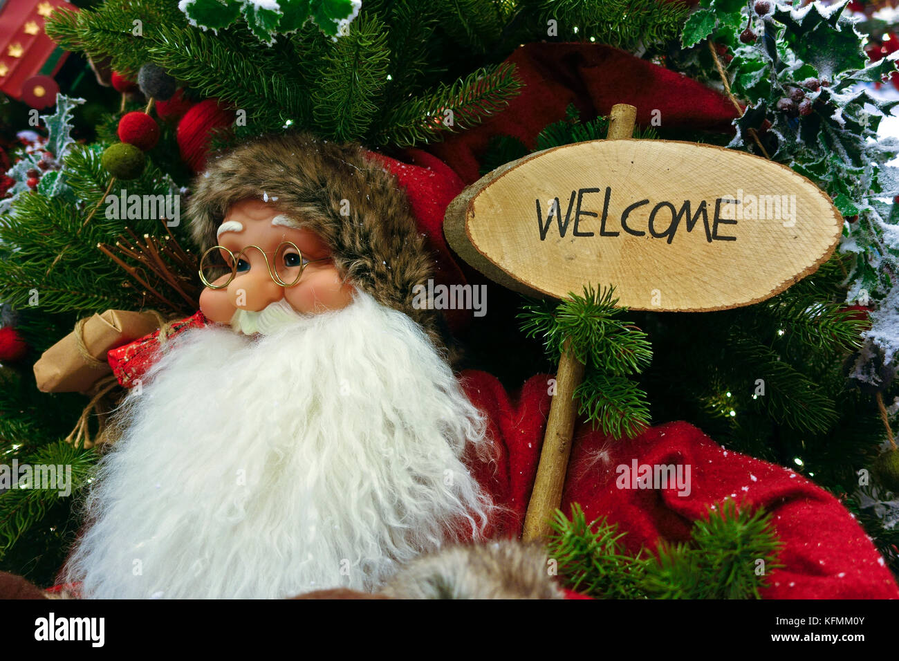 Santa Claus figure, christmas tree decoration, holding a board reading Welcome. Close up Stock Photo