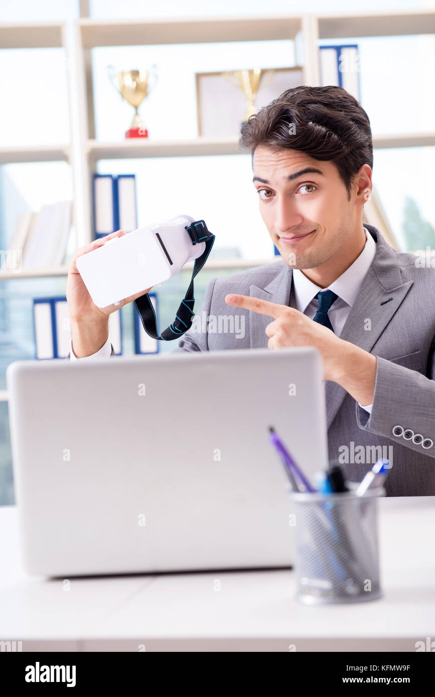Businessman with VR virtual reality glasses in office Stock Photo - Alamy