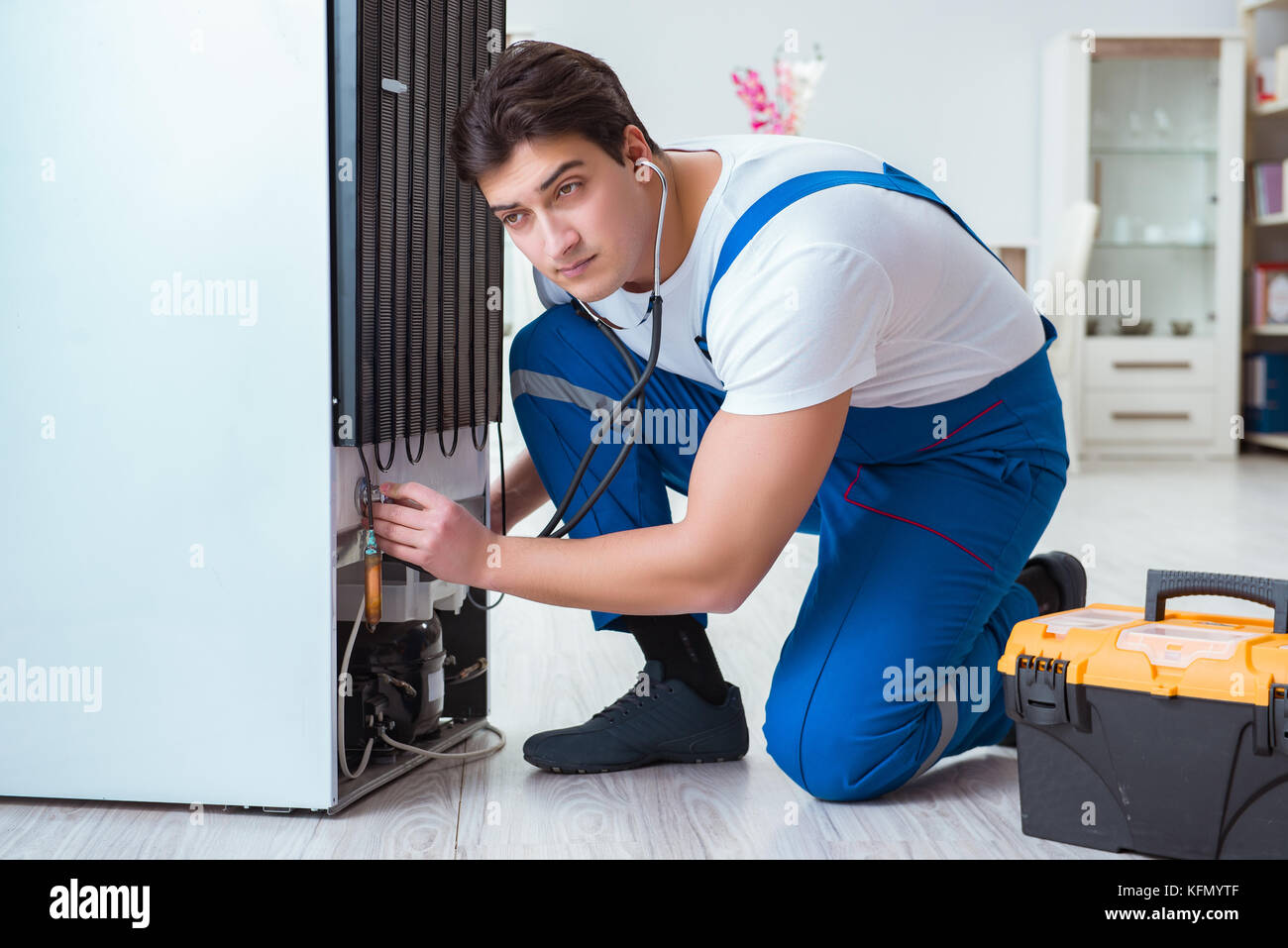Repairman contractor repairing fridge in DIY concept Stock Photo Alamy