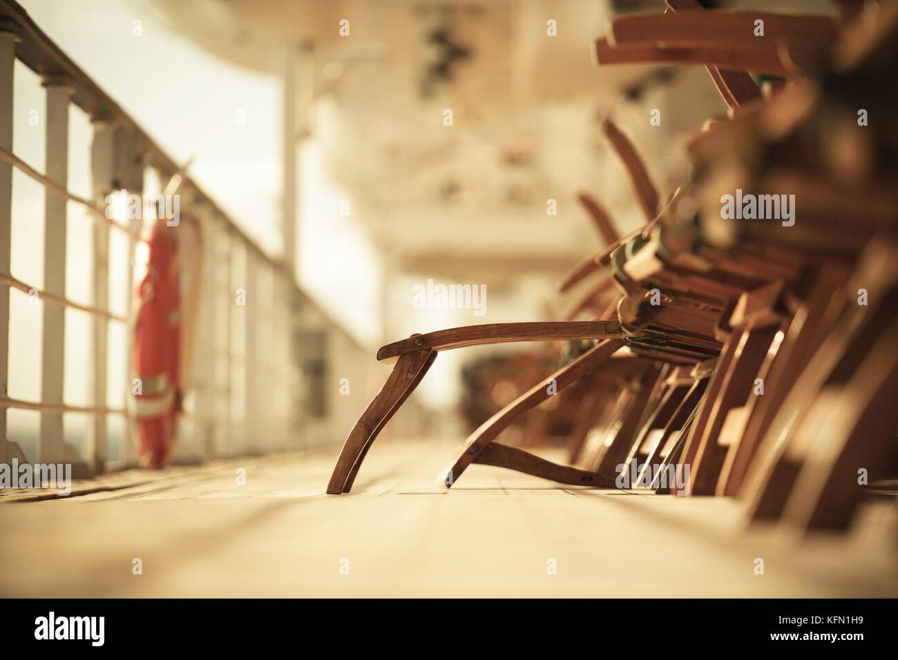 Empty Wooden Deckchairs on the Cruise Ship Main Deck. Just One Unfolded Chair. Stock Photo