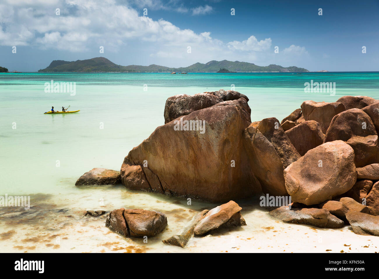 The Seychelles, Praslin, Anse Volbert, Cote d’Or beach couple in sea kayak at Anse Gouvernment Stock Photo