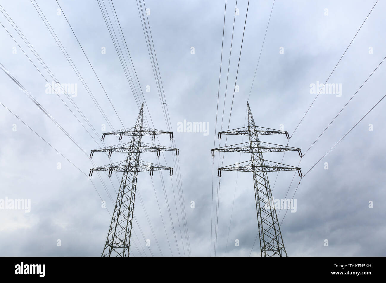 Overhead power line masts, low angle view up, Germany Stock Photo