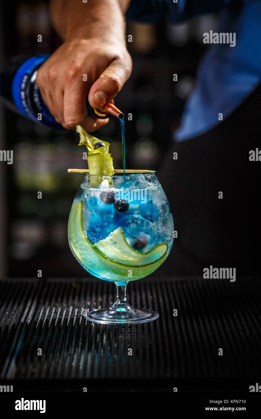Bartender preparing a blue gin tonic with curacao Stock Photo Alamy