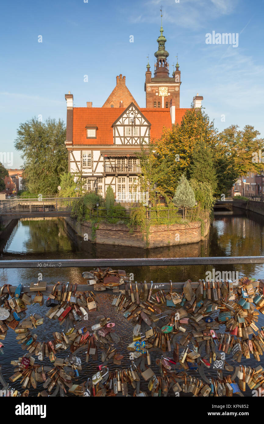 View of many love locks at the Love Bridge and Miller's House at the Mill Island on Raduni Canal in Gdansk's Old Town in Poland on a sunny day. Stock Photo