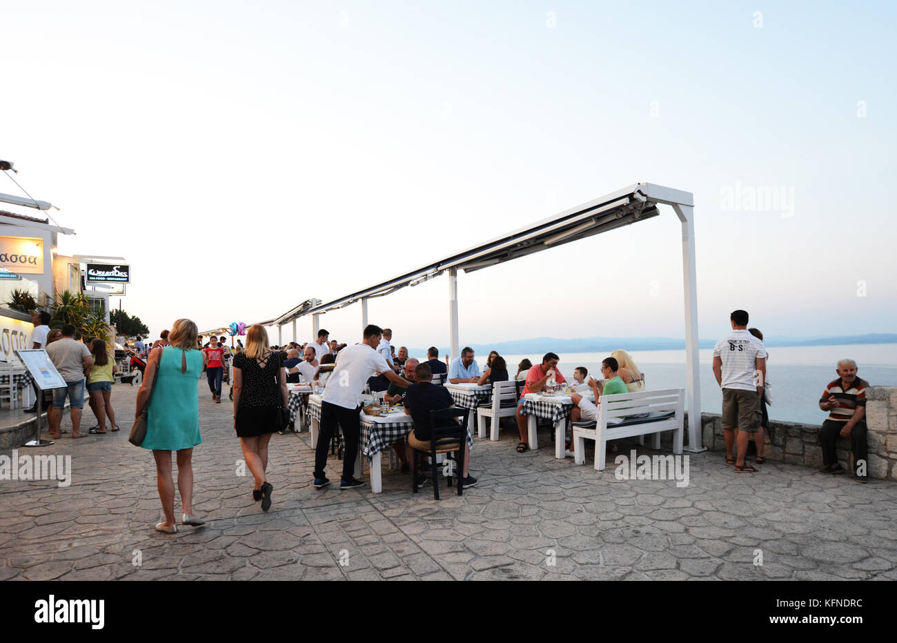 Seafood restaurants overlooking the ocean in Afitos village, Chalkidiki, Greece. Stock Photo