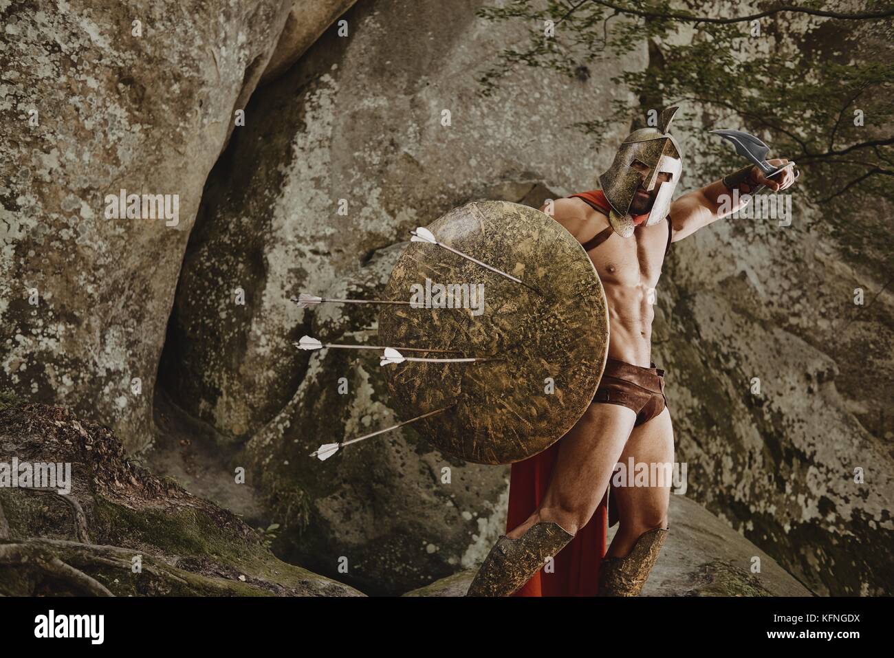 Muscular shirtless man wearing metal helmet and gladiator armor posing ...