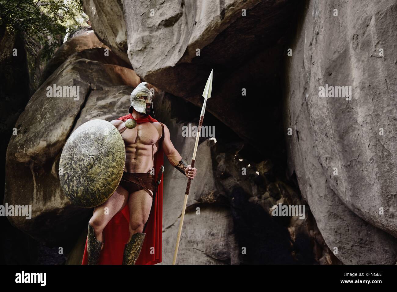 Strong and muscular man holding spear and shield while posing in ...