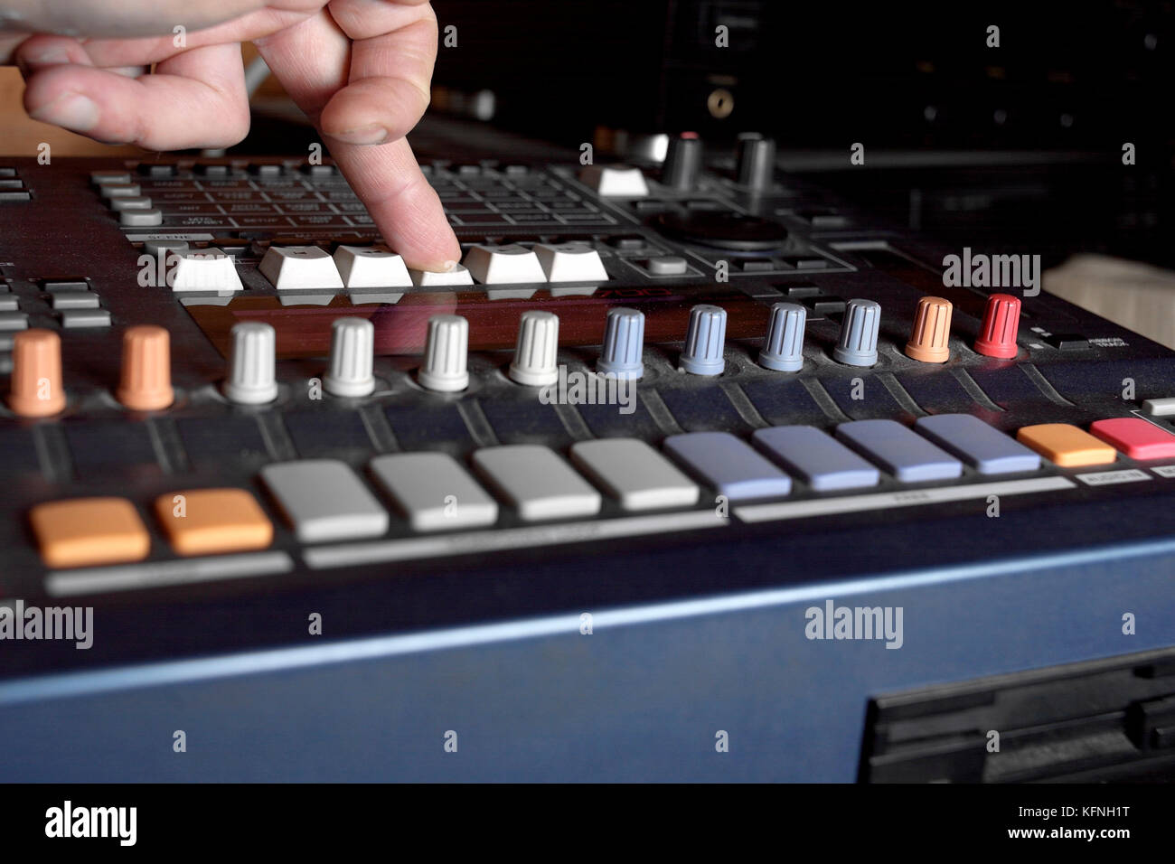 Musician hand pressing knob on a musical device Stock Photo - Alamy