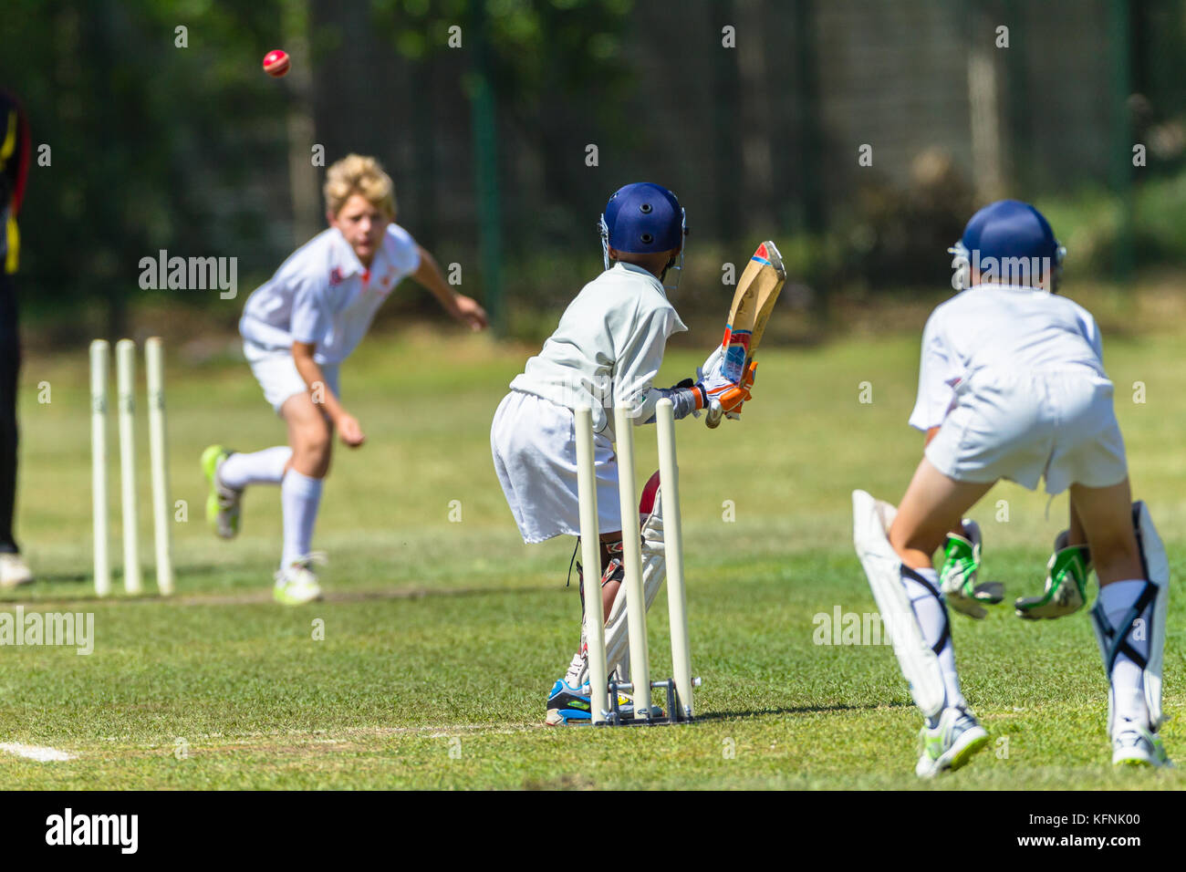 Cricket game juniors players bowler Batsman wicket keeper unidentified action abstract. Stock Photo