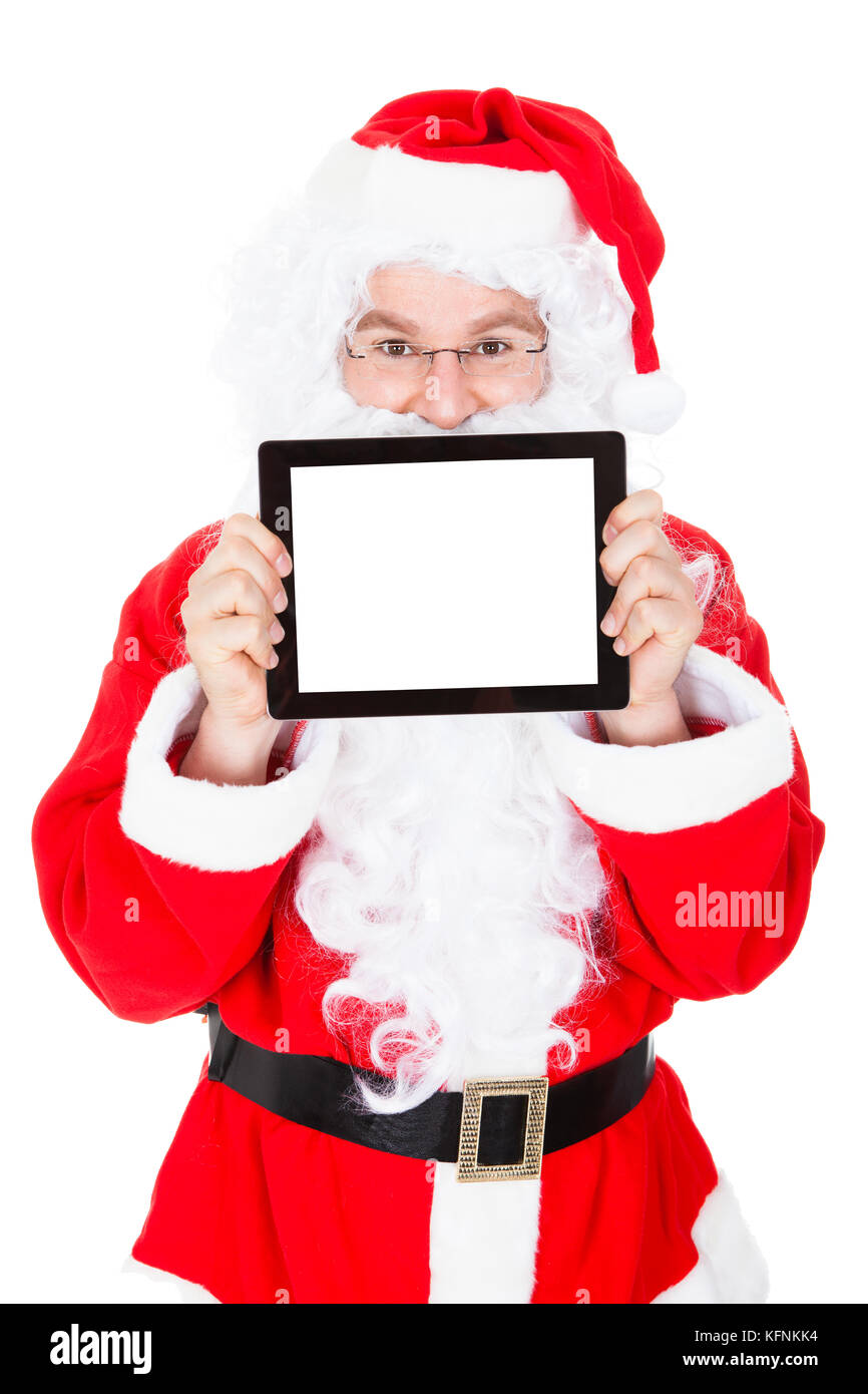 Portrait of santa pointing at digital tablet over white background ...