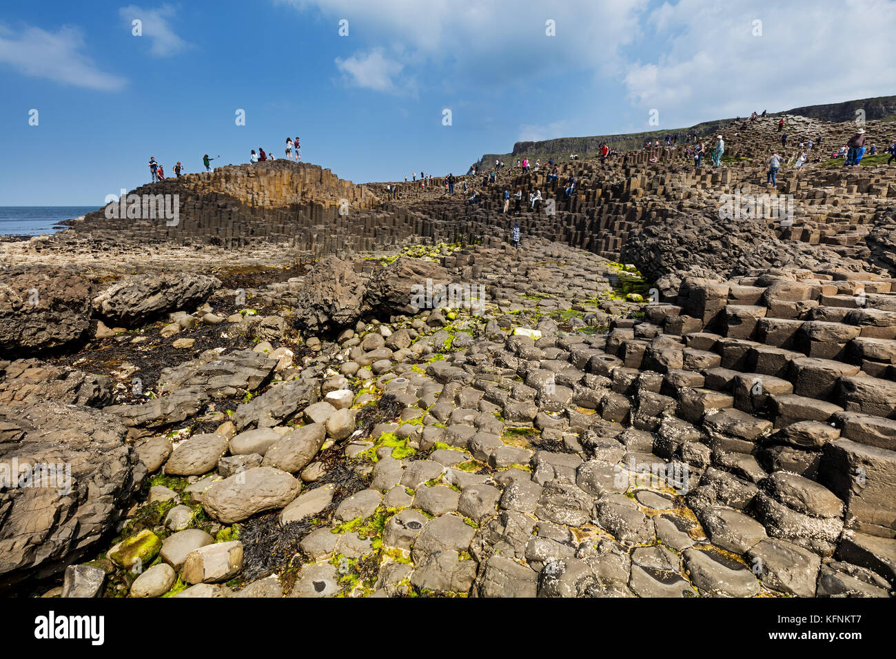 Thousands of tourists visiting Giant's Causeway in County Antrim of Northern Ireland, a World Heritage Site by UNESCO containing about 40000 interlock Stock Photo