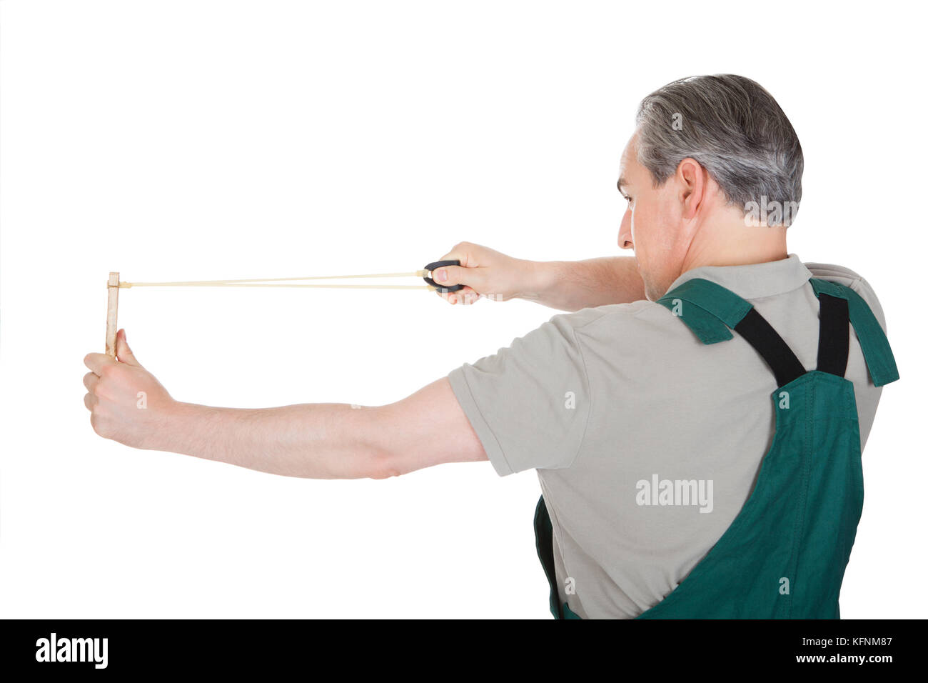 Close-up of hand pulling sling shot on white background Stock Photo