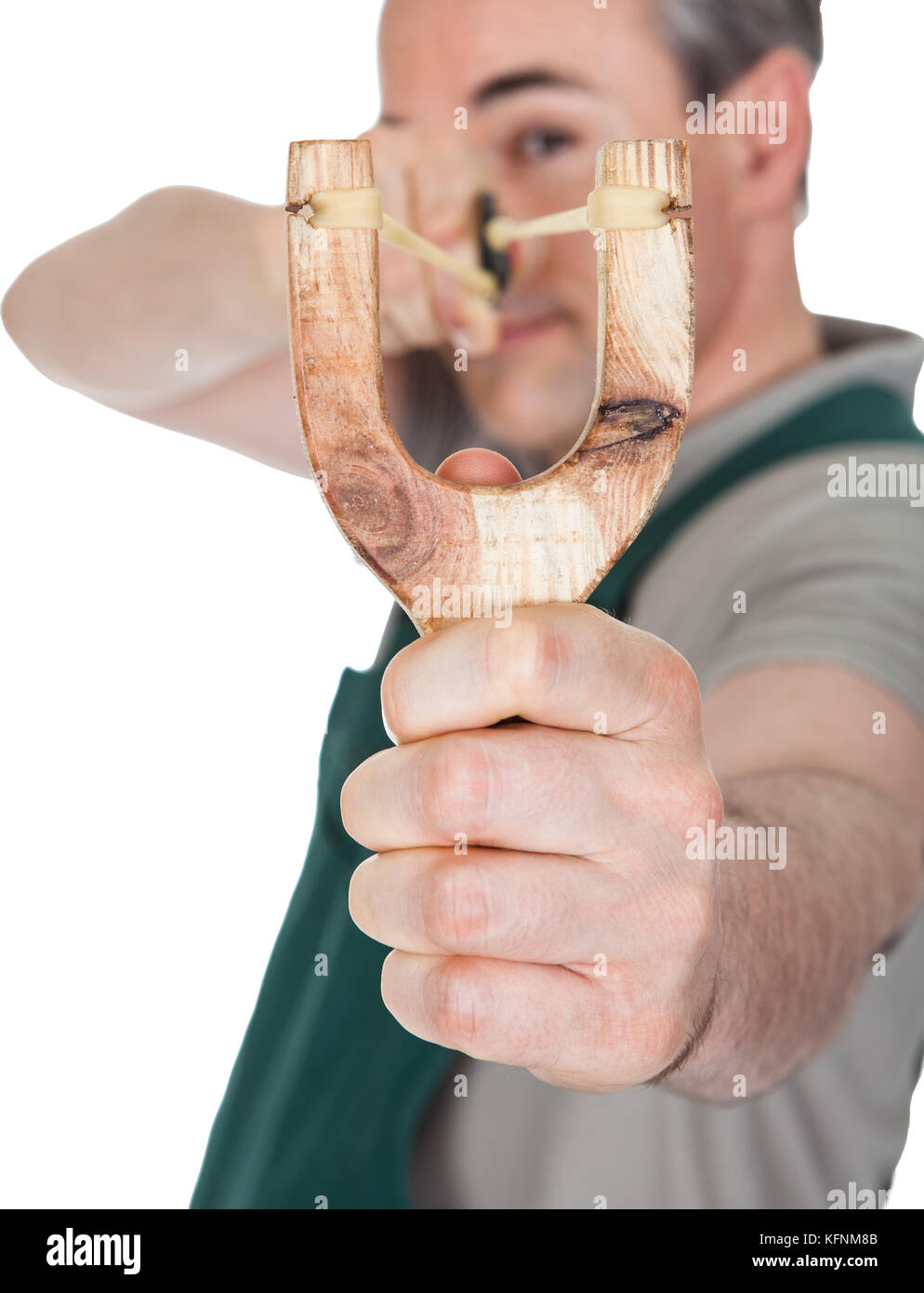 Close-up of hand pulling sling shot on white background Stock Photo