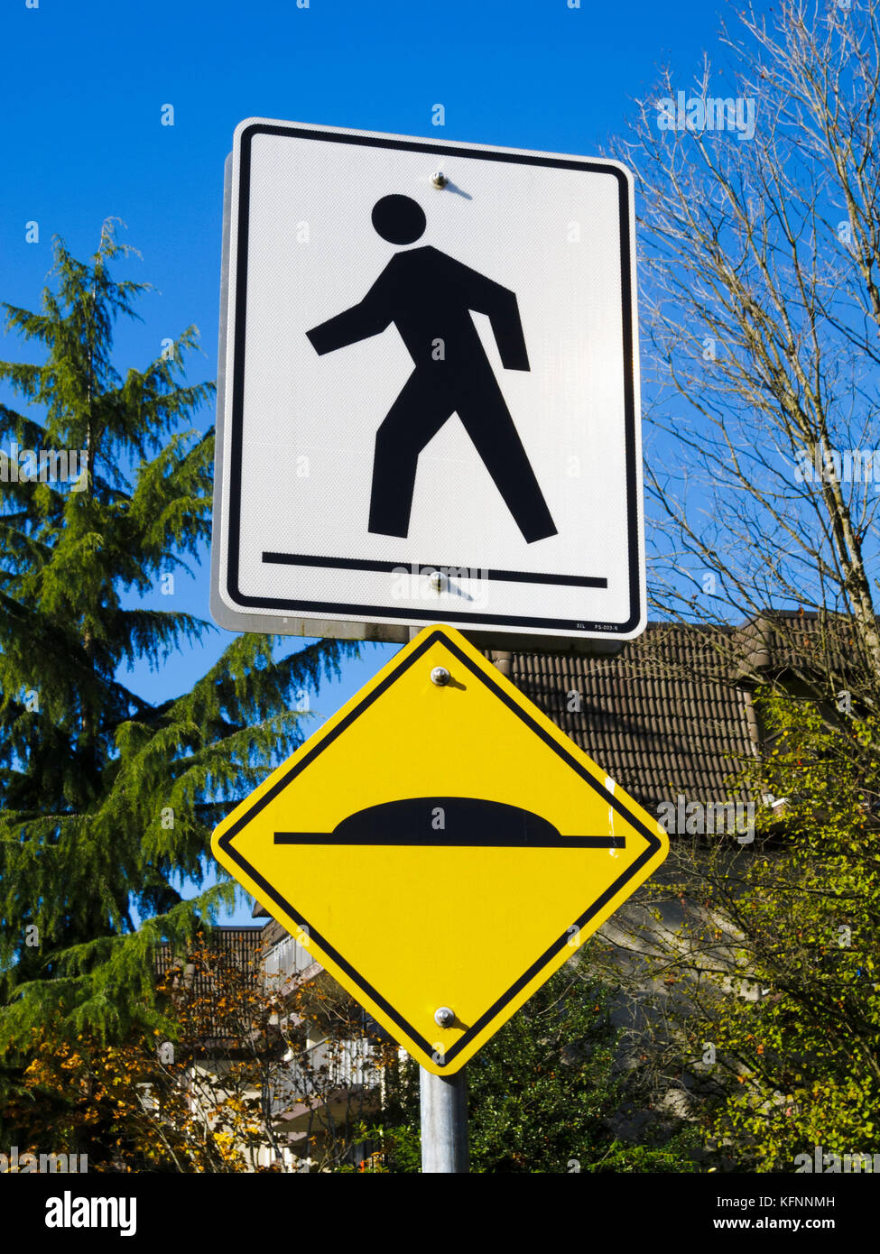 Signs warning for pedestrian crossing and speed bump Stock Photo