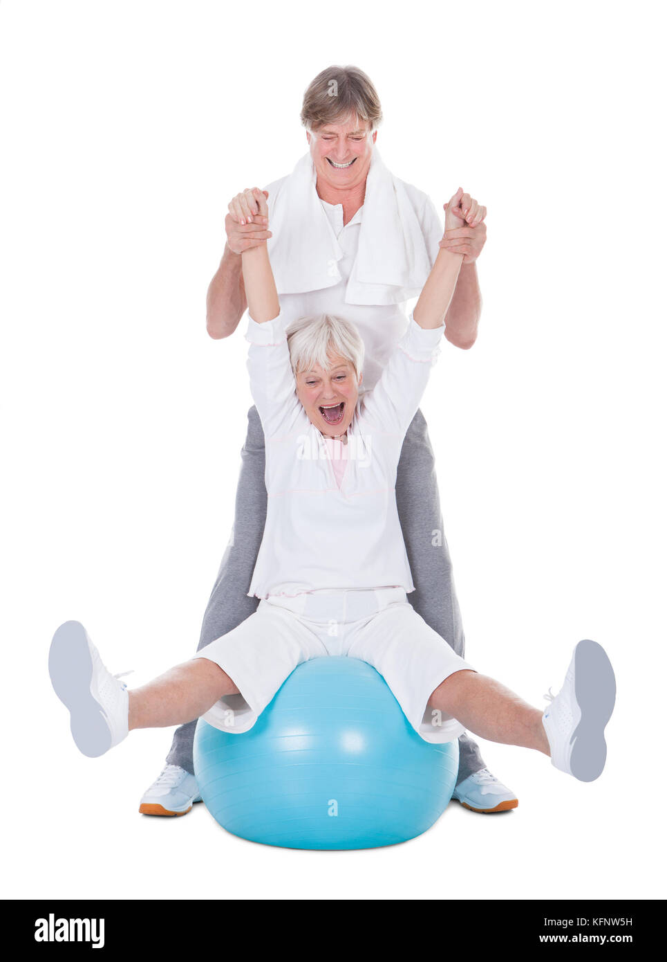 Happy Senior Couple Exercising With Fitness Ball On White Background Stock Photo