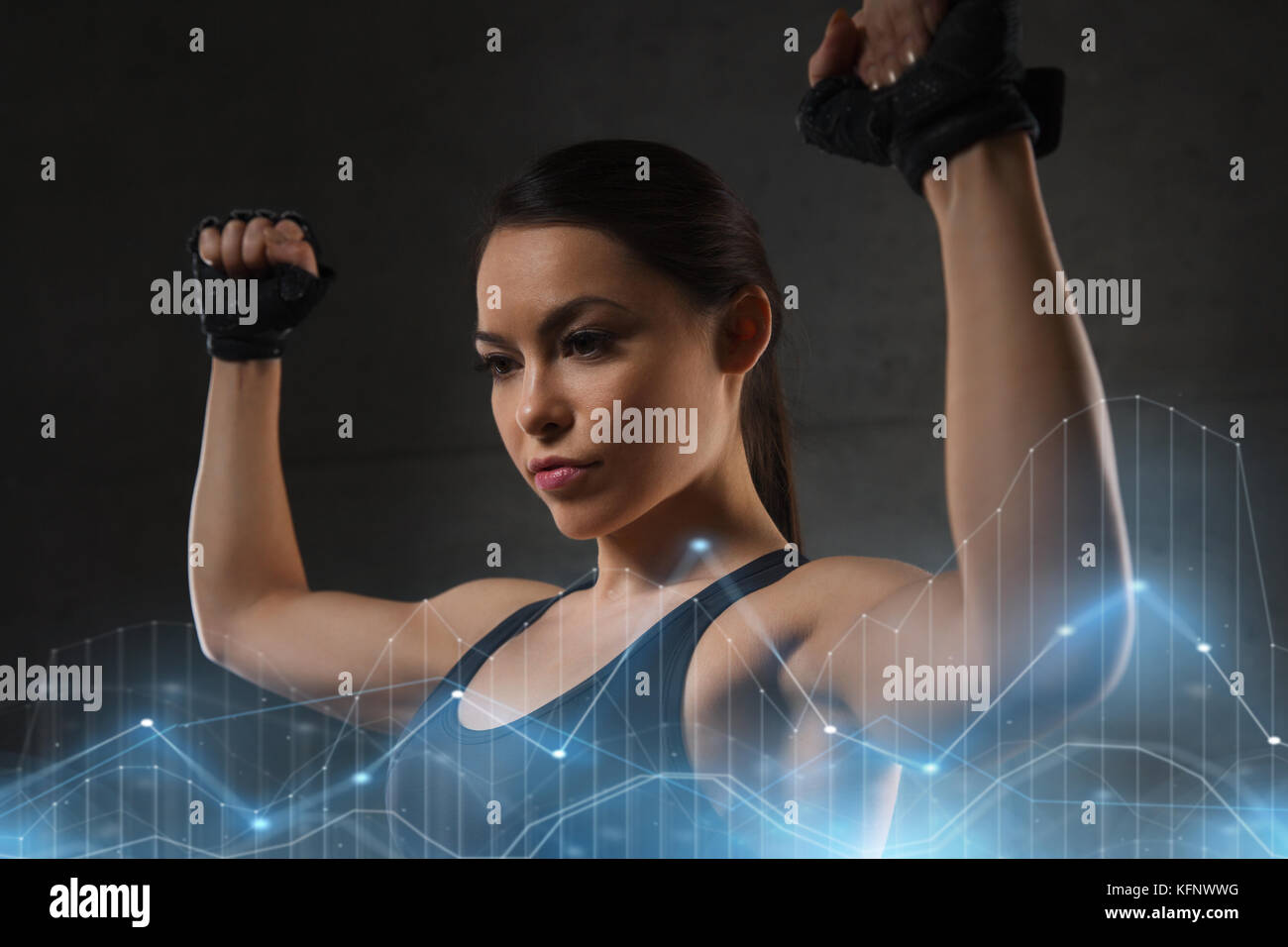 young woman flexing muscles in gym Stock Photo