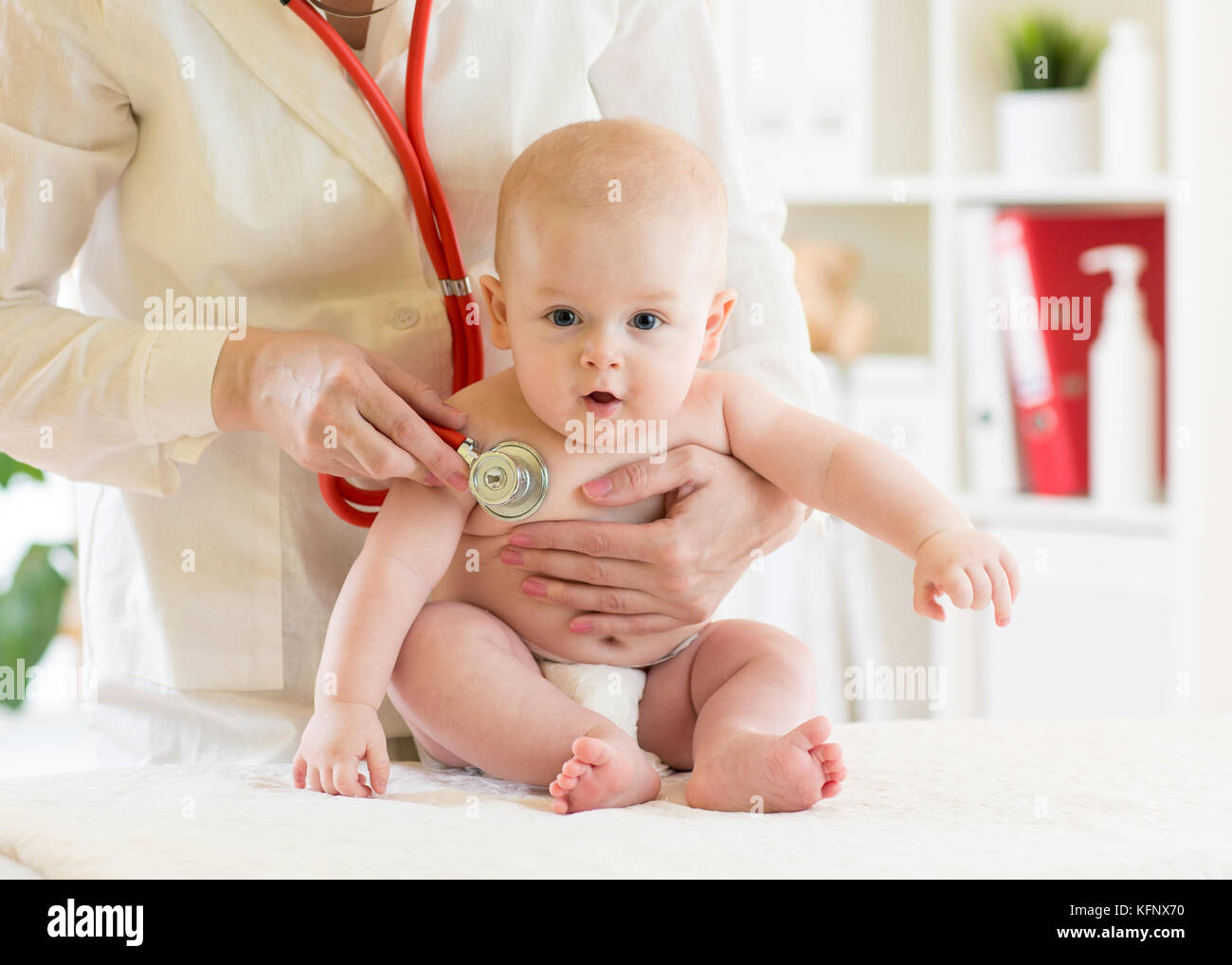 Doctor pediatric examining little baby in clinic. Baby health concept Stock Photo