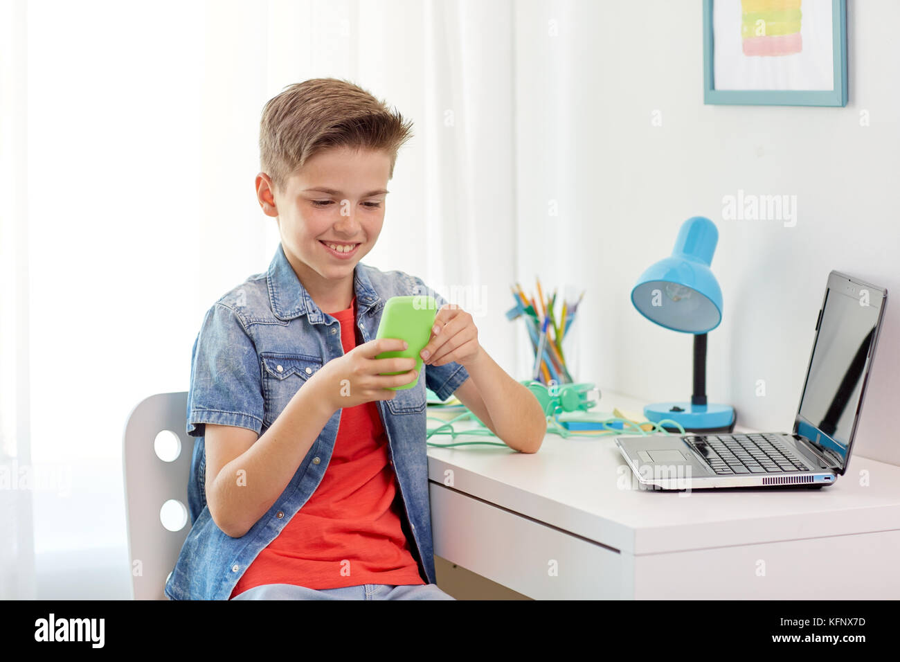 happy boy with smartphone and laptop at home Stock Photo - Alamy