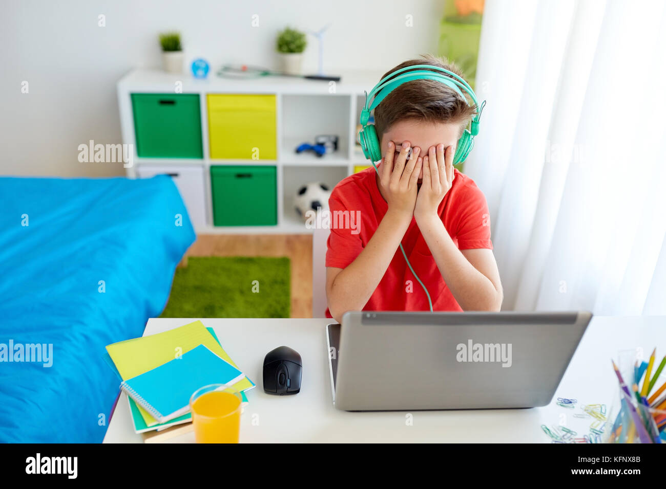 boy in headphones playing video game on laptop Stock Photo