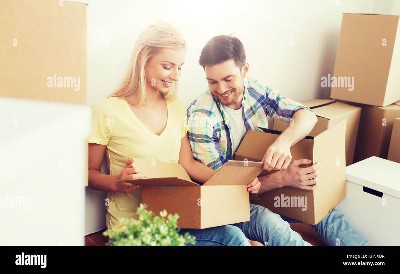 smiling couple with many boxes moving to new home Stock Photo - Alamy